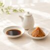 小皿に入れた醤油と味噌、白い陶器の醤油差しのイメージ